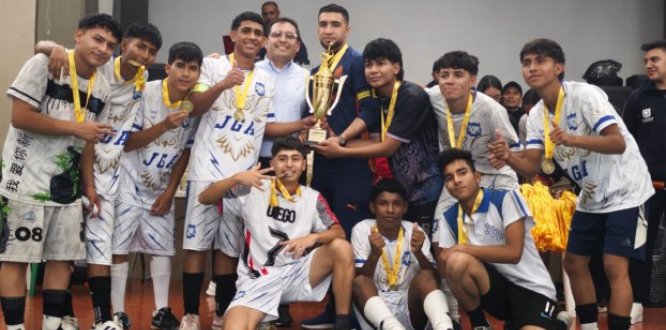 Pasión, esfuerzo y victoria: así vivió Puente Aranda los Juegos Intercolegiados 2025 Un grupo de estudiantes celebra su victoria en los Juegos Intercolegiados 2025 de Puente Aranda. Los jóvenes, vestidos con uniformes deportivos y medallas doradas en el cuello, posan sonrientes alrededor de un gran trofeo dorado que sostienen junto a dos adultos. La escena refleja alegría, unión y logro colectivo al finalizar la competencia deportiva.